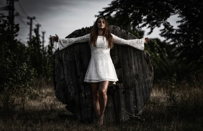 Woman in white dress in Jesus Christ pose