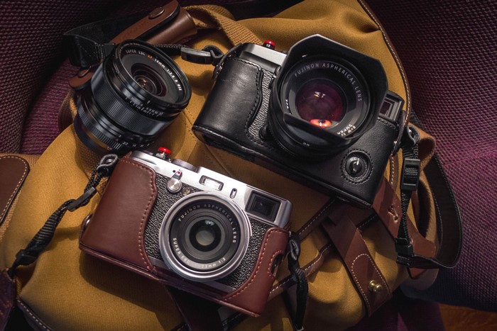 Two Fujifilm cameras and a lens on a bag
