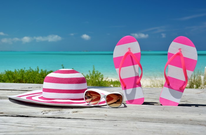 Summer beach accessories: hat, sunglasses, and flip-flops