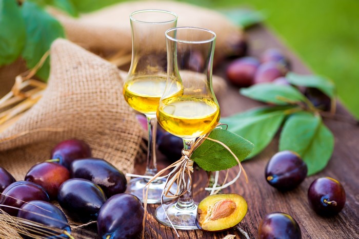 Two glasses of plum liqueur with plums