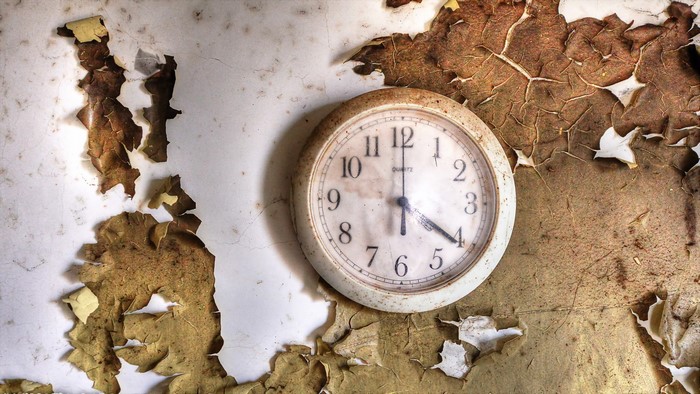 Old clock on a peeling wall