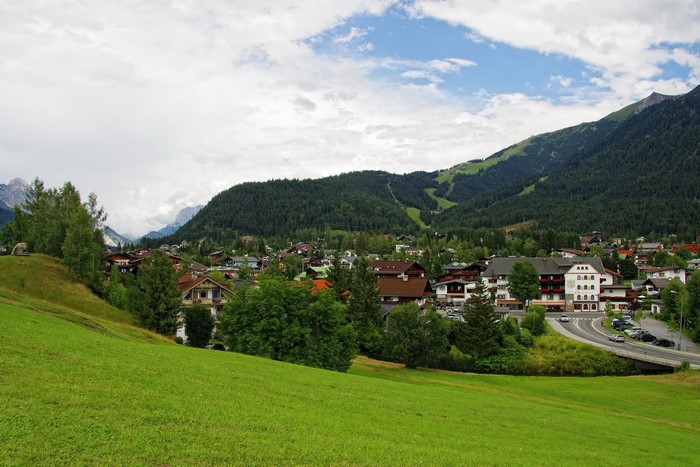 Village nestled in Austrian Alps with green meadows