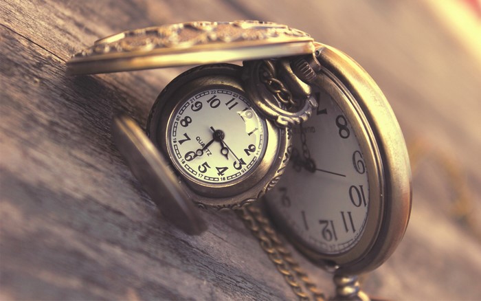 Antique pocket watch on a wooden surface