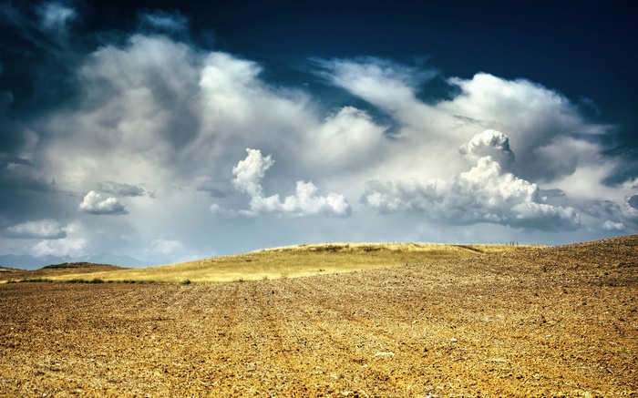 Plowed field under dramatic stormy sky