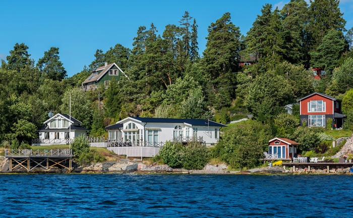 Houses on a wooded hillside by the water in Sweden