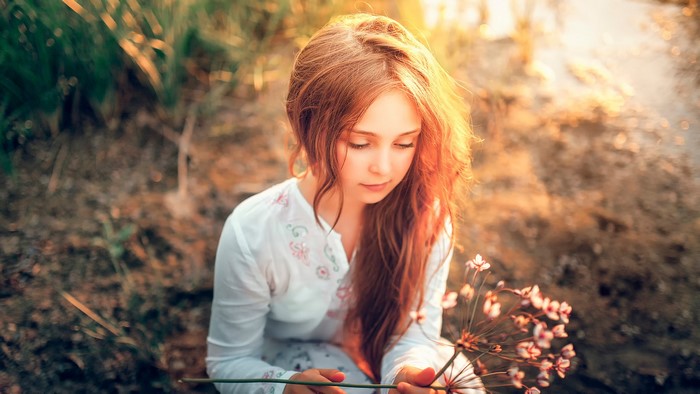 Girl with long brown hair holding flowers
