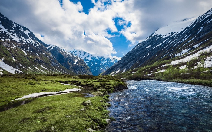 Mountain valley with a river and snow-capped peaks
