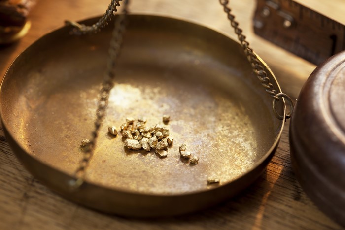 Gold nuggets on a brass scale
