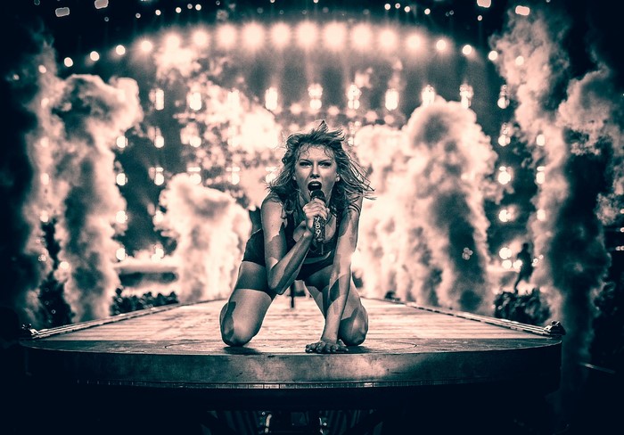 Taylor Swift performing on stage with smoke effects