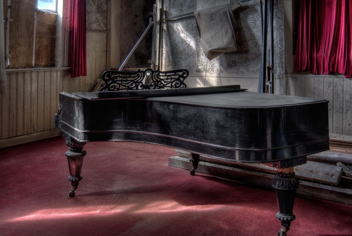 A grand piano in an abandoned room