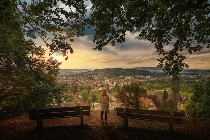 Woman watching over a city from a hill in Switzerland