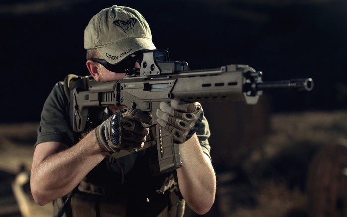 Soldier aiming an assault rifle with a baseball cap