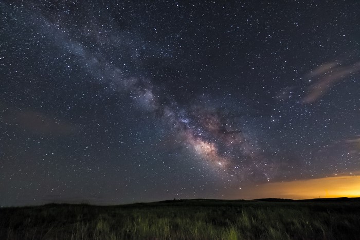 Milky Way galaxy over a grassy field at night