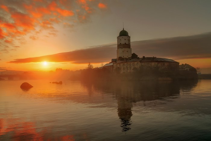 Vyborg Castle at sunrise over the water