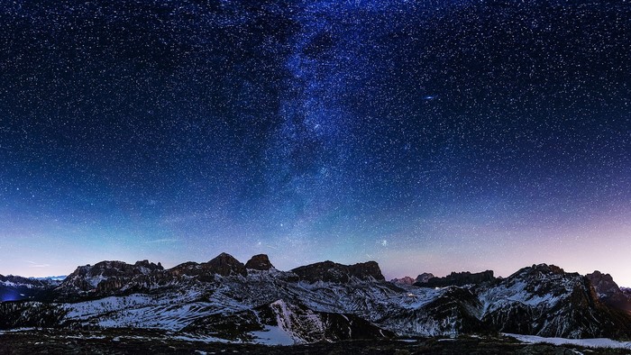 Milky Way over snow-capped mountains at night
