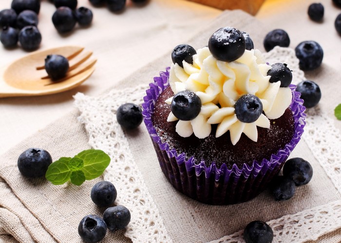 Chocolate cupcake with white frosting and blueberries
