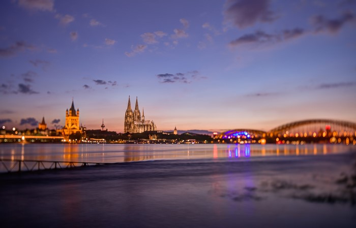 Cologne Cathedral and bridges over the Rhine River at dusk