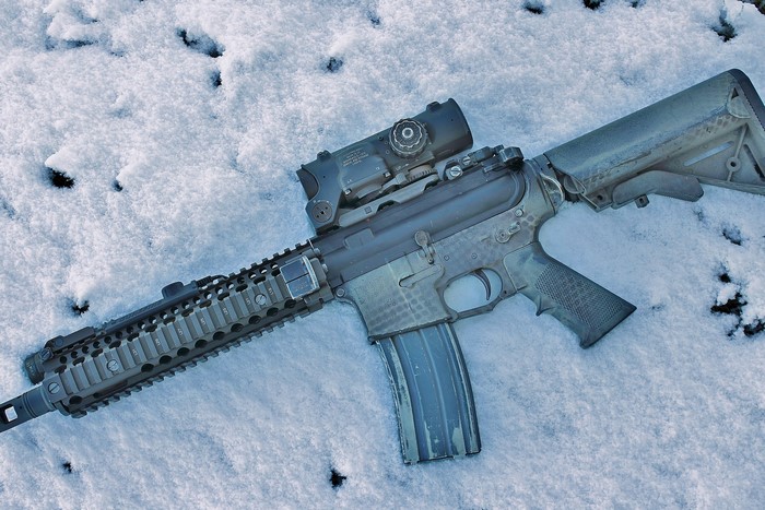 AR-15 rifle with scope in snow