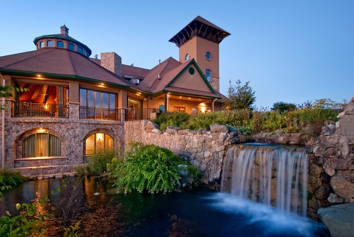 Luxury villa with pond and waterfall at dusk