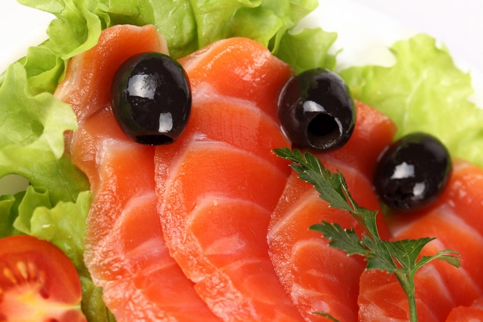 Salmon slices with olives and lettuce