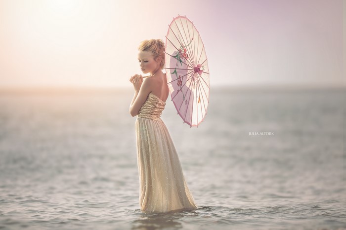 Girl with umbrella in the sea