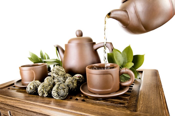 Tea ceremony with teapot, cups, and tea balls