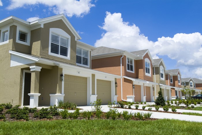 Row of townhouses with garages and blue sky