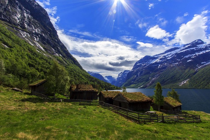 Traditional Norwegian houses by a lake with mountains