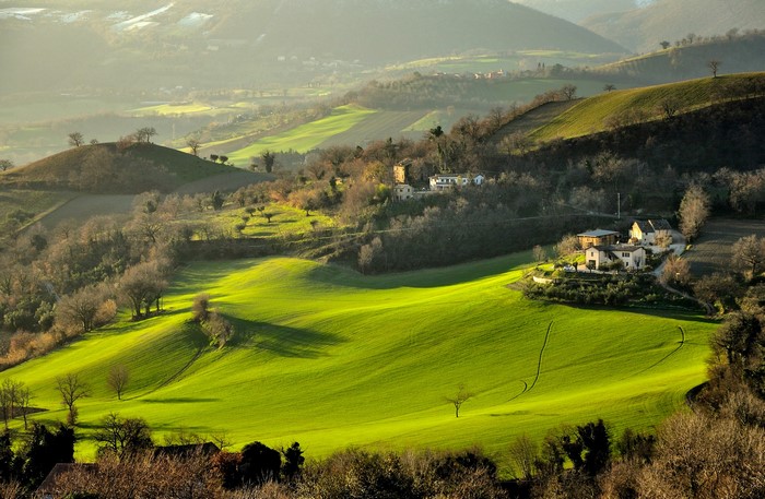 Rolling green hills and farmhouses in Italy