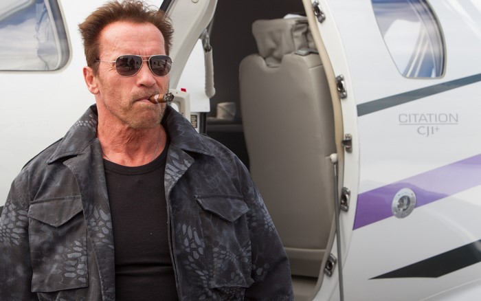 Arnold Schwarzenegger with cigar on private jet
