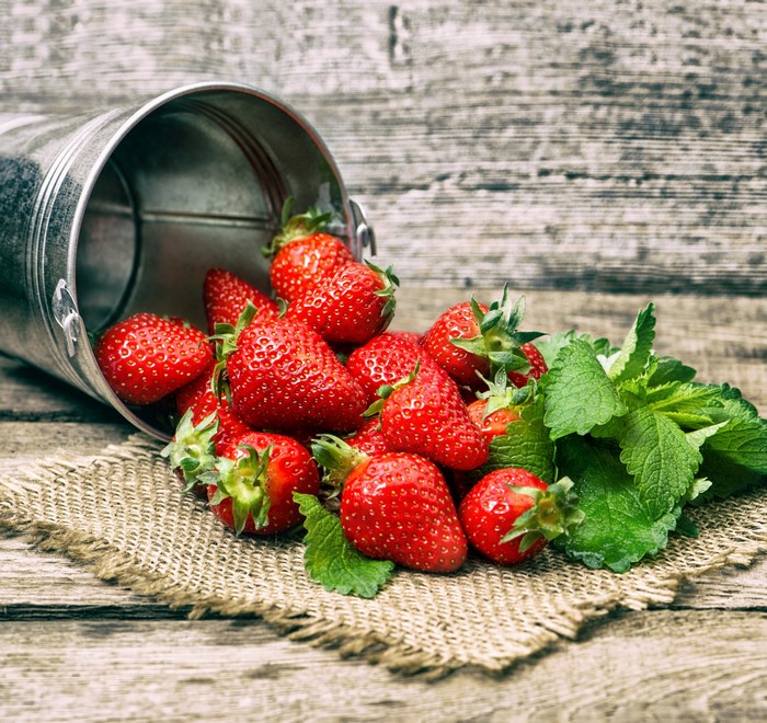 Strawberries spilling from a bucket
