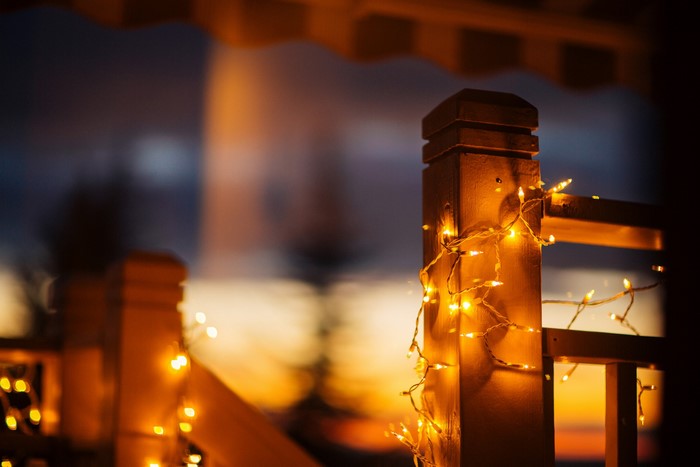 Wooden post with fairy lights at dusk