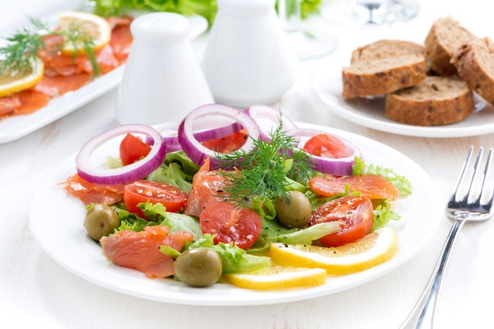 Salmon salad with tomatoes, onions, lemons, and olives