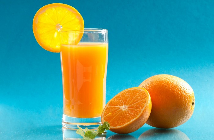 Glass of orange juice with oranges and mint