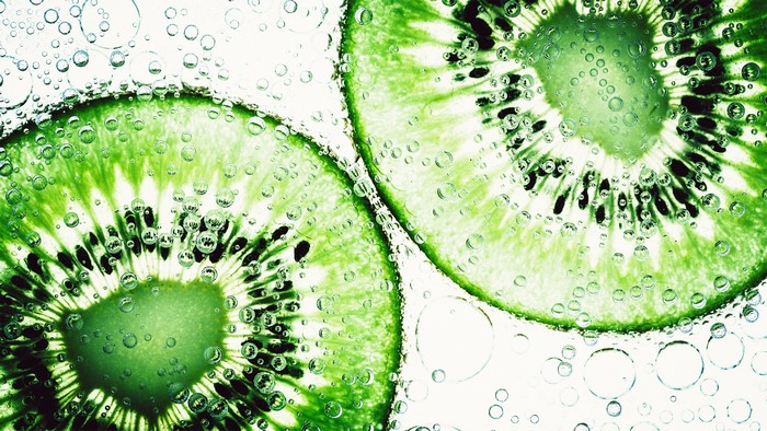 Close-up of kiwi slices in water with bubbles