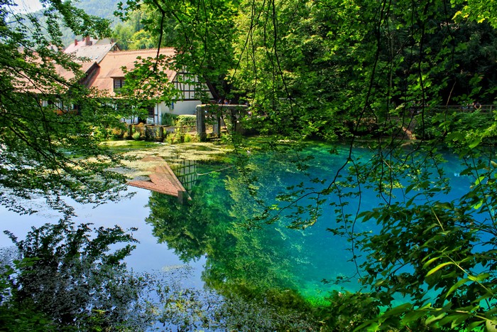 Half-timbered houses reflected in a clear blue spring in Blaubeuren, Germany