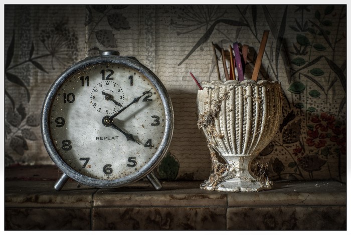 Old alarm clock and vase with sticks