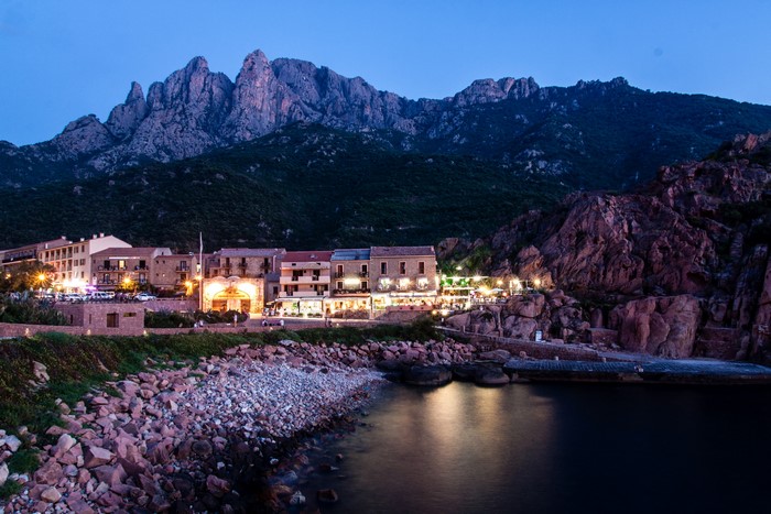 Coastal town at dusk with mountains in Corsica, France