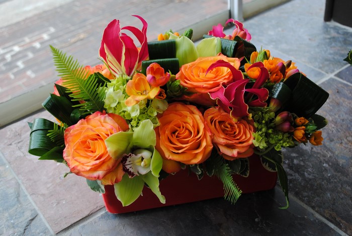 Orange Roses and Orchids in a Red Vase