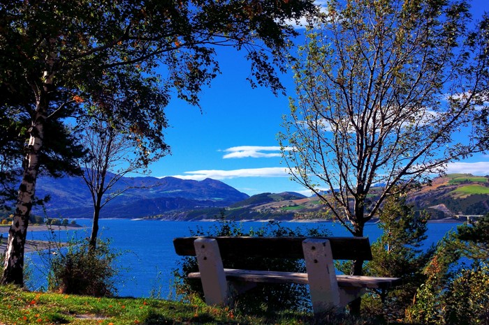 Bench overlooking a lake and mountains in Savines le Lac, France