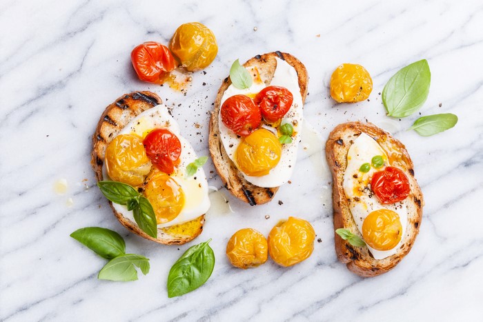 Bruschetta with tomatoes, mozzarella, and basil on marble