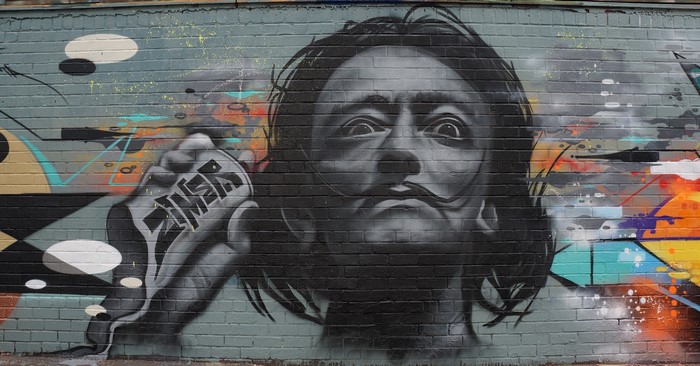 Graffiti of Salvador Dali holding a spray can