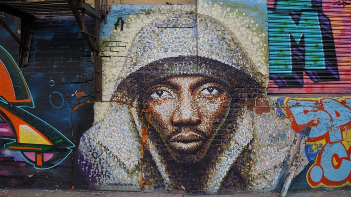 Graffiti of a man's face on a brick wall