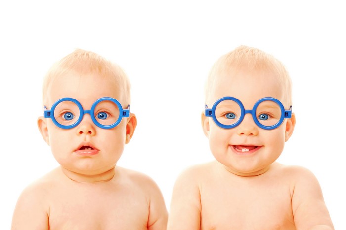 Two infants wearing blue glasses