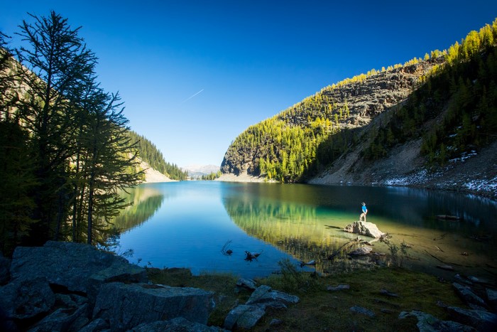 Man standing on rock in a mountain lake