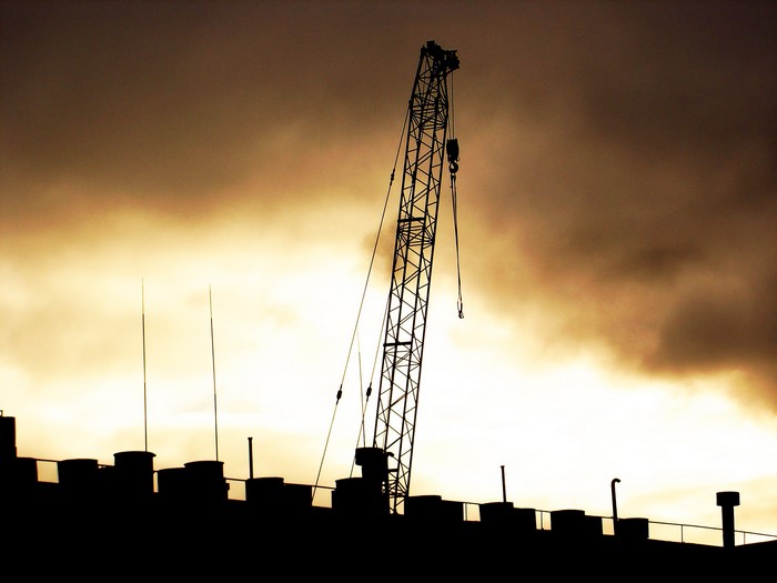 Silhouette of a crane against a cloudy sky