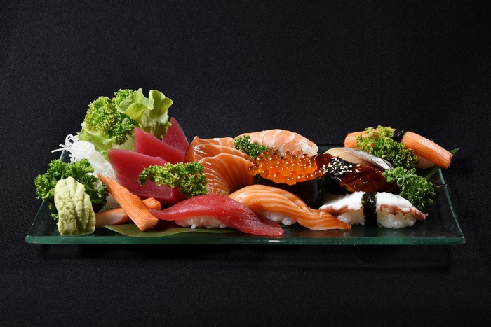 Assortment of Sushi and Sashimi on a Glass Plate