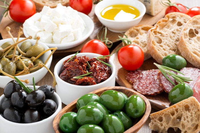 Appetizer platter with olives, tomatoes, cheese, and bread