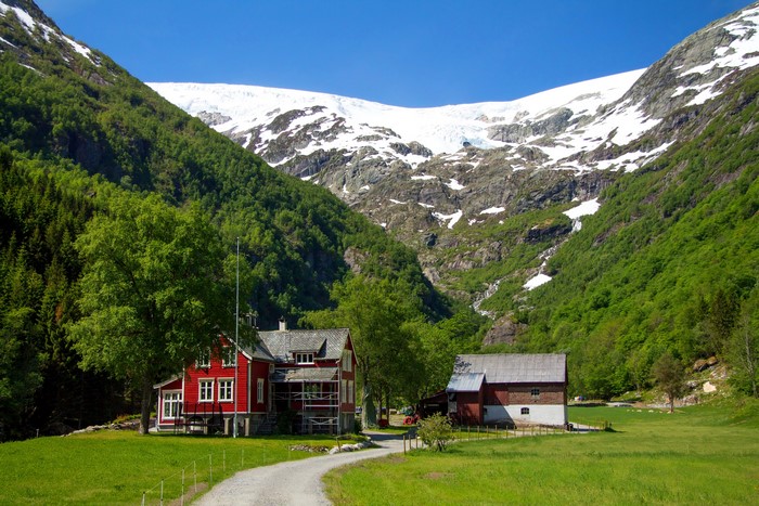 Houses in a valley with mountains and glacier, Norway