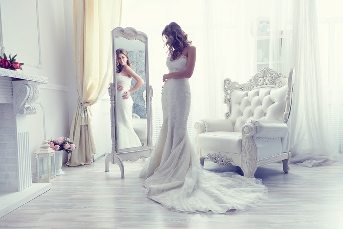 Bride in a white dress looking in a mirror